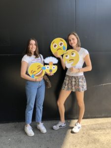 zwei Studenten mit Emojis in den Händen - traurig, nachdenklich, lachend und erschrocken