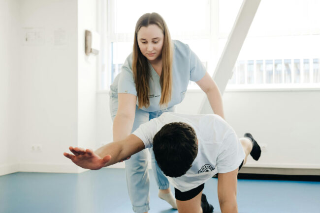 Erfahrungsbericht Physiotherapie Studium FH JOANNEUM Person übt praktische Übungen für die Physiotherapie-Aufnahmeprüfung an der FH JOANNEUM